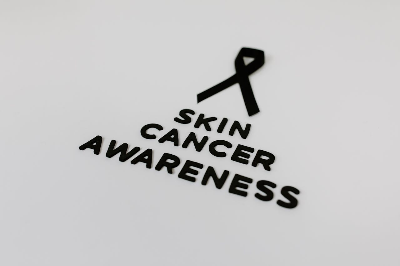 Black ribbon symbolizing skin cancer awareness on a white background.